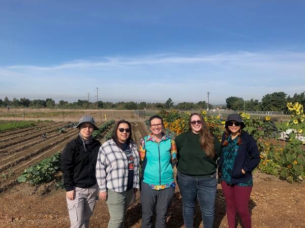 Five researchers in front of field crops